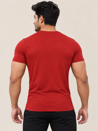 A man viewed from behind wearing a RED short-sleeve crewneck t-shirt and black pants, set against a solid beige background.