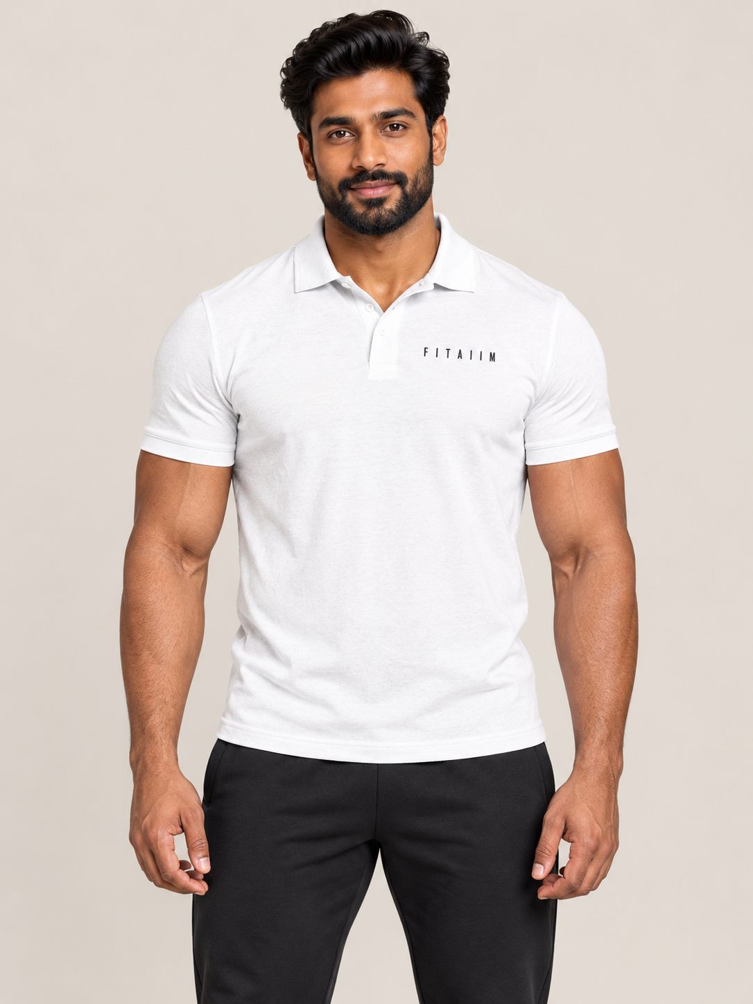 A muscular man wearing a white short-sleeve polo shirt with 'FItaiim' printed on the chest, paired with black pants, against a solid light beige background.