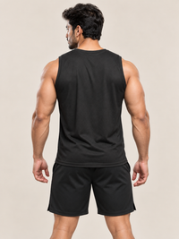 A muscular man shown from the back wearing a black sleeveless athletic tank top and matching black shorts against a plain beige studio background.