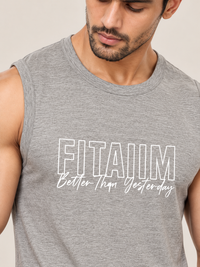 A close-up of a man wearing a heather gray sleeveless tank top with the text 'FITAIIM Better Than Yesterday' printed in white on the front, against a plain light beige background.