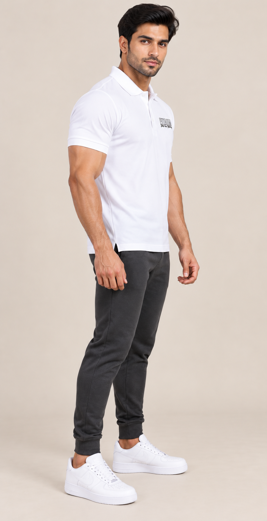 A man modeling a short-sleeve polo shirt in WHITE, paired with black jogger pants and white sneakers, standing against a solid light beige background.