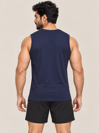 A muscular man shown from the back wearing a navy blue sleeveless athletic tank top and black shorts, set against a plain beige studio background.