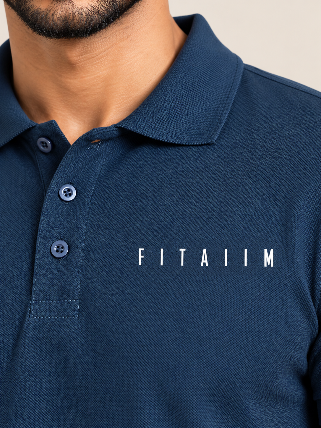 Close-up of a man wearing a navy blue polo shirt with the brand name 'FITAIIM' printed in white on the chest.