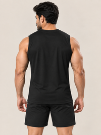 A muscular man shown from the back wearing a black sleeveless athletic tank top and matching black shorts against a solid light beige background.