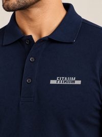 A close-up of a man wearing a NAVY BLUE short-sleeve polo shirt with a gray and white 'FITAIIM' graphic printed on the left chest.